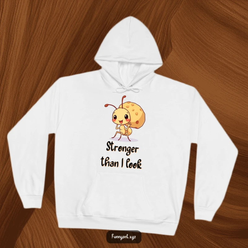 Funny hoodie depicting a cute ant character beaming while carrying an enormous crumb, symbolizing inner strength and unwavering determination.